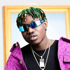 Zlatan Ibile poses in sunglasses and a purple outfit amid ongoing Mohbad death controversy.